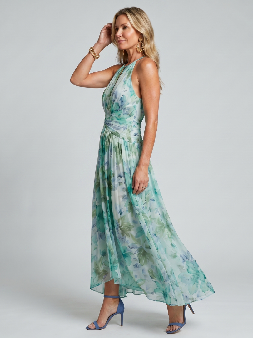 Close-up of the vibrant floral print and elegant pleats on a comfortable green halter midi dress.