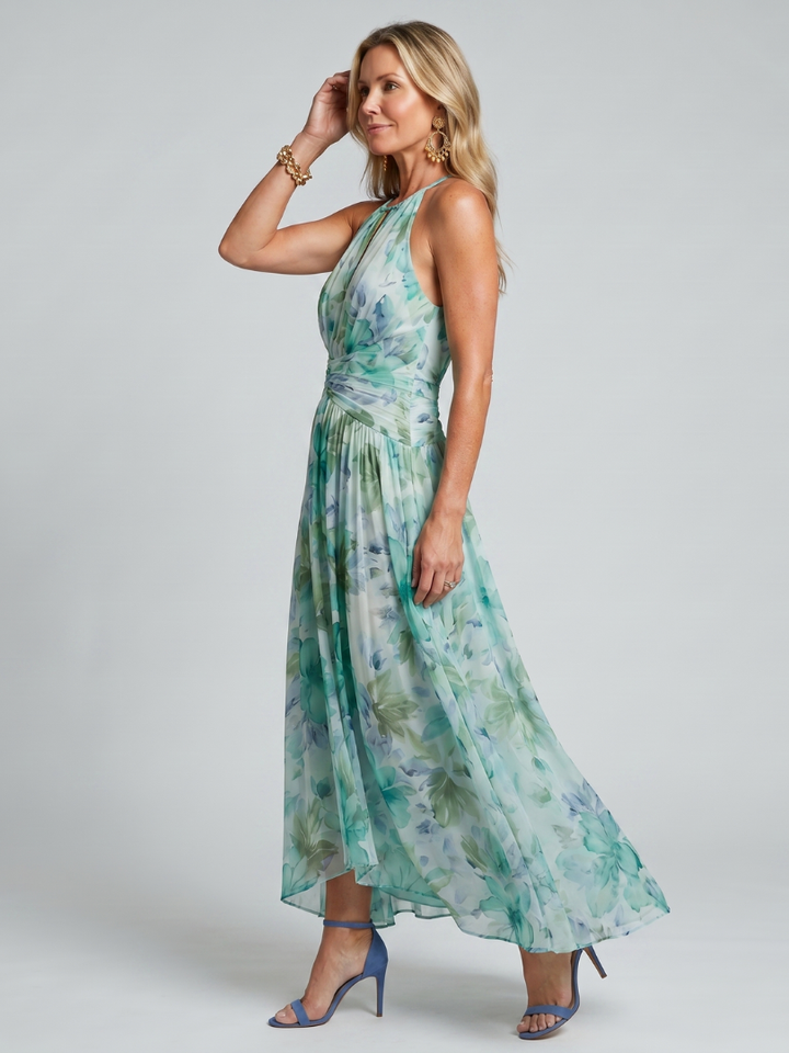 Close-up of the vibrant floral print and elegant pleats on a comfortable green halter midi dress.