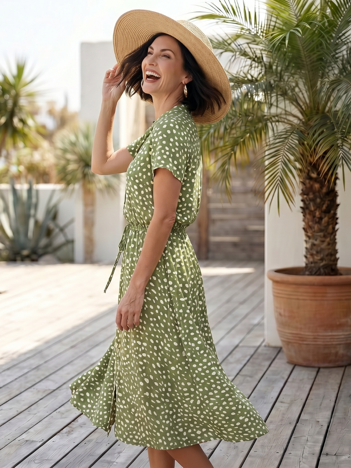 Close-up of the vibrant print on a women's short sleeve midi dress, showing button details and fabric texture.