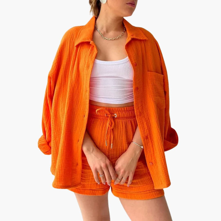 Front view of woman in a chic three-piece summer set: button shirt, crop top & high-waist shorts. Matching.