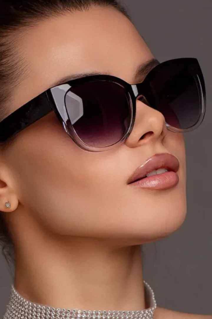 Fashionable women's oversized cat eye sunglasses with gradient black frames and protective lenses.