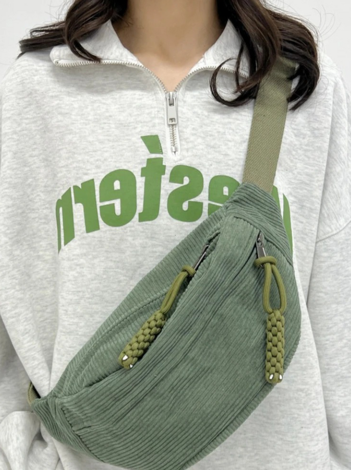 Vibrant green corduroy shoulder bag for unisex style. Converts to a hip pouch. Versatile everyday accessory.