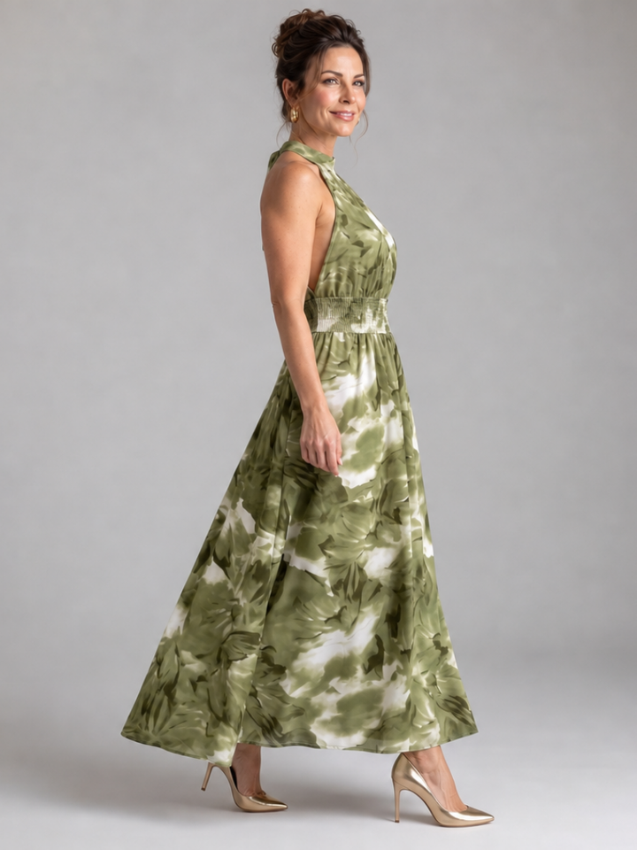 Stylish women's halter midi dress with a vibrant abstract print and flattering gathered waist. Casual summer look.
