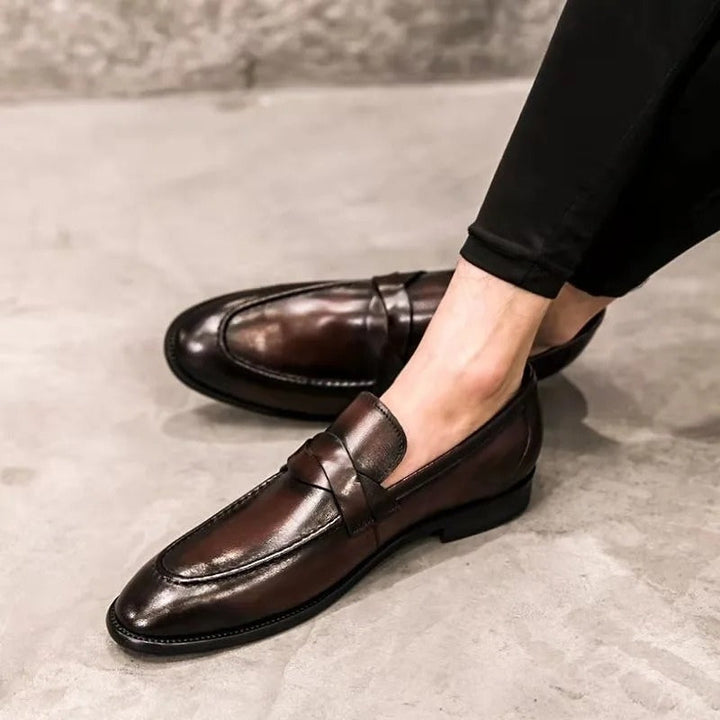High-shine black leather men's slip-on penny loafers, a timeless & comfortable choice for dressy or casual looks.