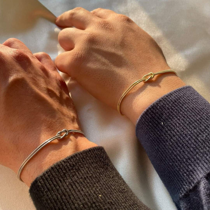Women's elegant knot bracelet on a wrist, a subtle & refined stainless steel fashion accessory. Timeless design.