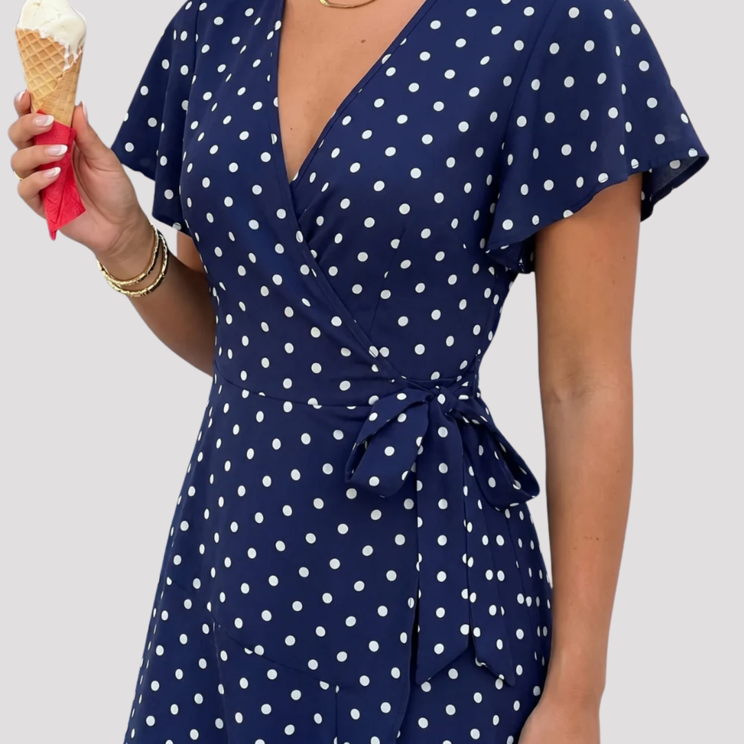 Stylish women's wrap midi dress featuring a polka dot pattern and flutter sleeves, suitable for casual or elegant occasions.