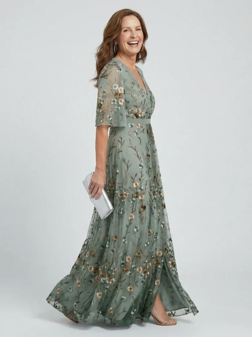 Elegant women's sage green maxi dress with delicate floral embroidery, flutter sleeves, and a chic drop waist.