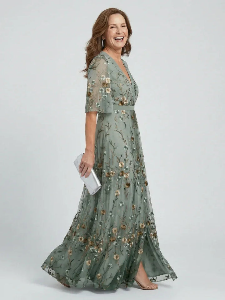 Elegant women's sage green maxi dress with delicate floral embroidery, flutter sleeves, and a chic drop waist.