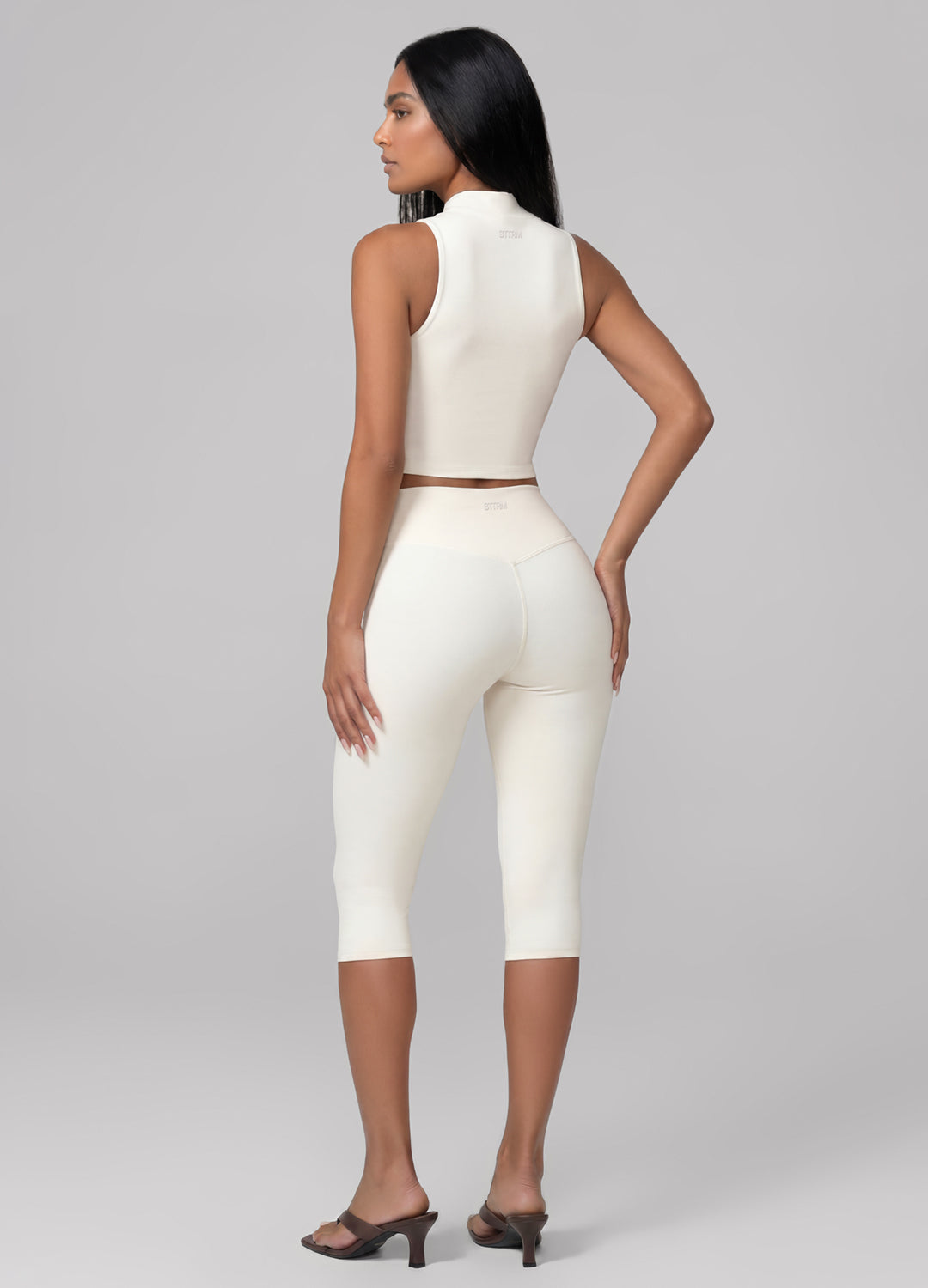 Chic ivory women's capri leggings, sculpting high-waisted design. Ideal loungewear or activewear for studio.