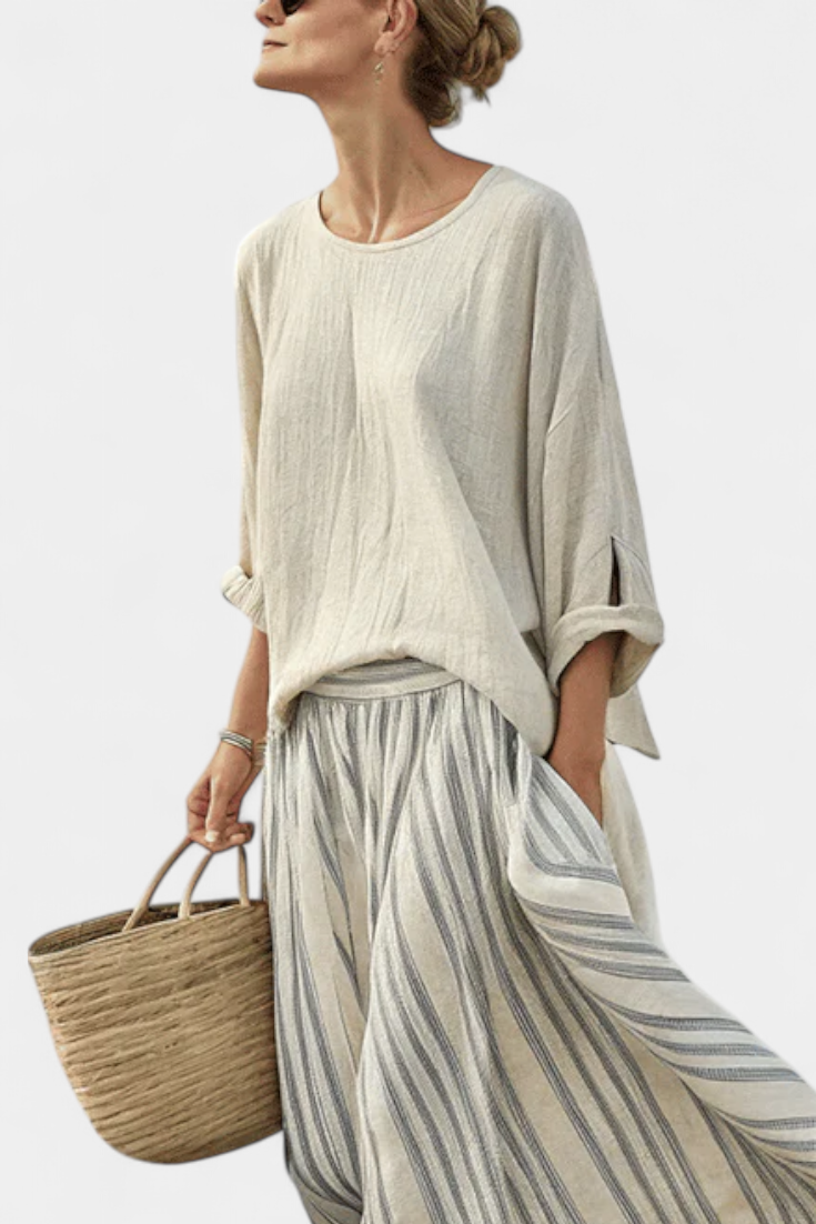 Elegant women's two-piece set featuring a loose beige top and a stylish striped midi skirt. Perfect for casual wear.