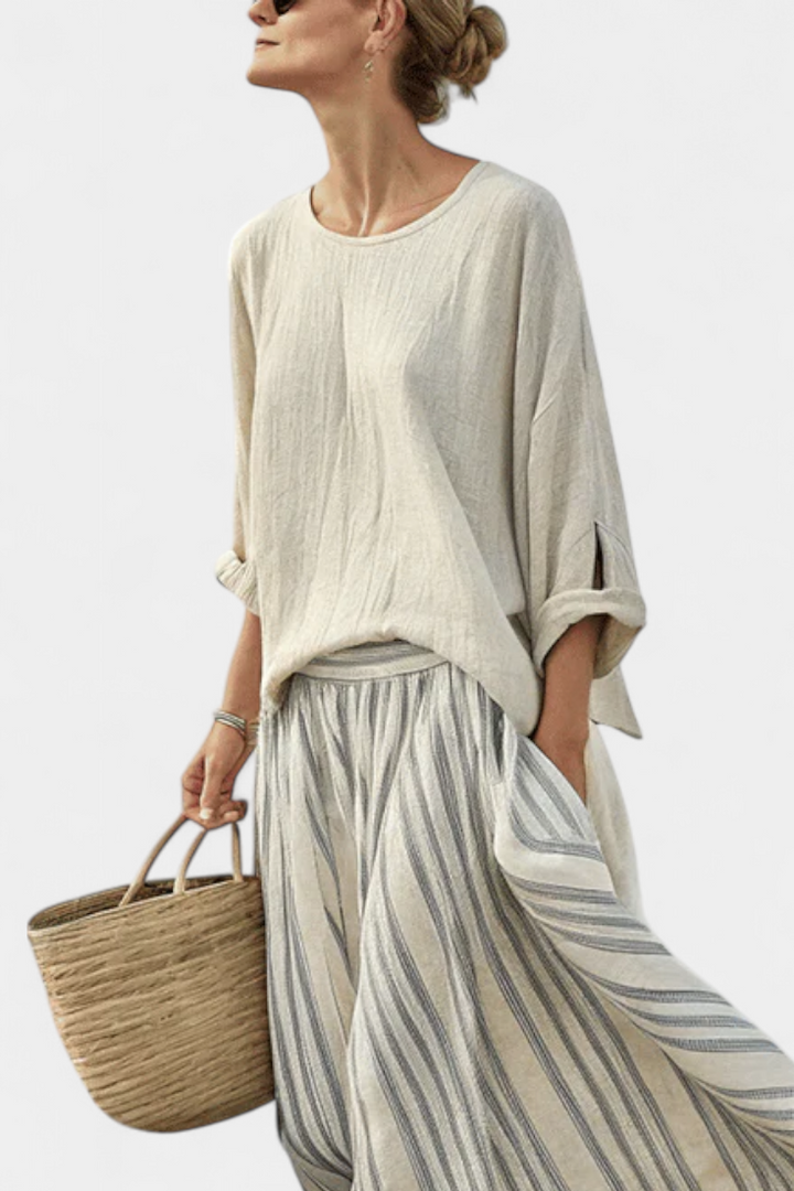 Elegant women's two-piece set featuring a loose beige top and a stylish striped midi skirt. Perfect for casual wear.