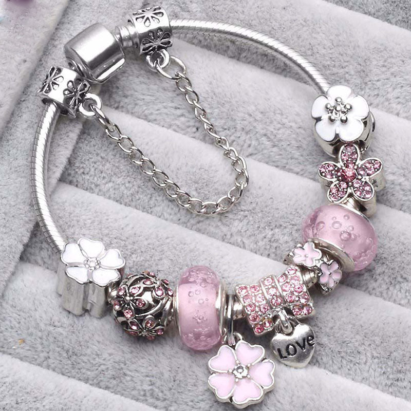 Elegant women's charm bracelet with vibrant peach blossom floral details; delicate and fashionable jewelry.
