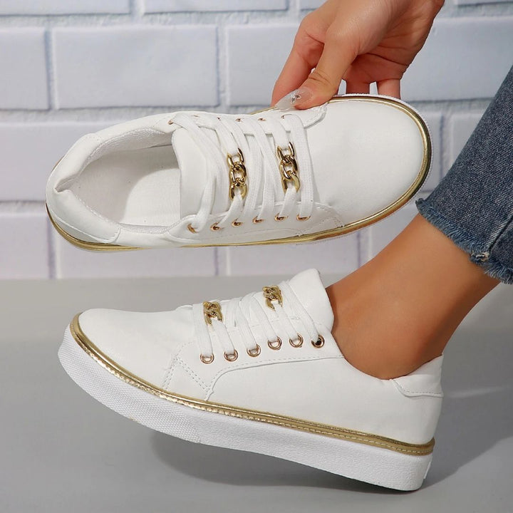 Women's comfortable white sneakers with elegant gold accents, perfect for versatile everyday casual wear.