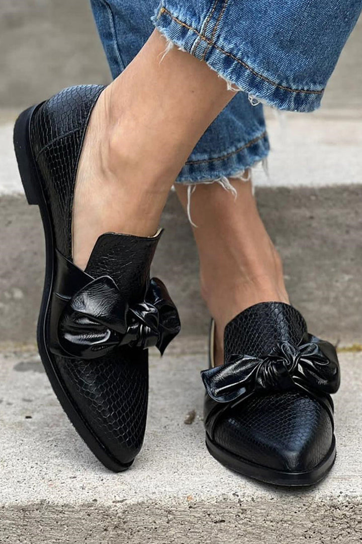 Stylish black bow loafers for women, offering a comfortable and elegant slip-on footwear option for any occasion.
