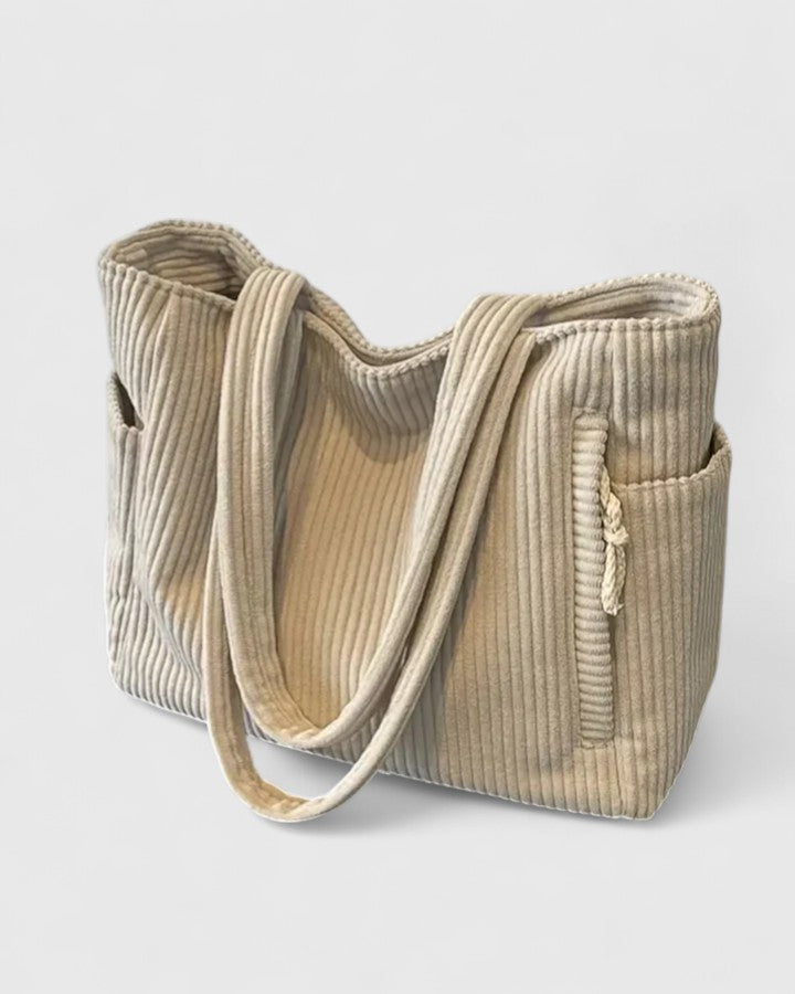 Close-up of a fashionable women's corduroy tote bag, highlighting its sophisticated texture.