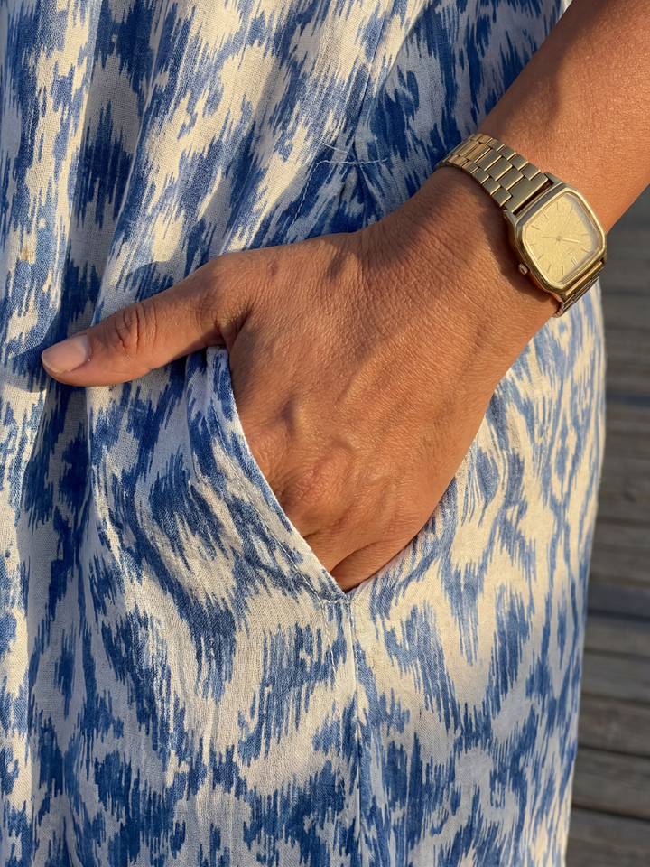 Flowy women's summer midi dress featuring a stylish geometric pattern. Comfortable, relaxed fit with short sleeves & V-neck.