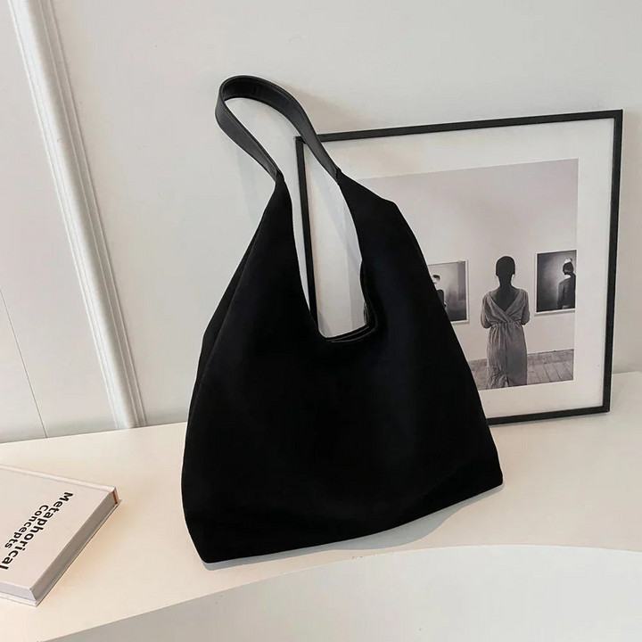 Modern black suede carryall tote bag, a versatile women's handbag for work or leisure.
