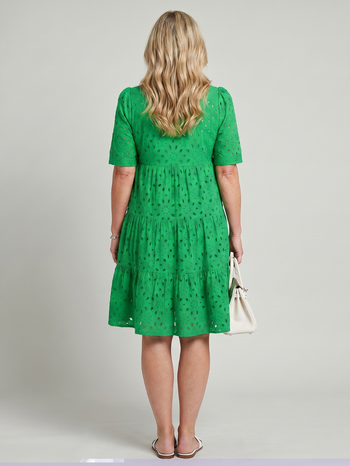 Casual yet elegant women's short sleeve eyelet summer dress, knee-length, featuring a V-neck and stylish tiered skirt.