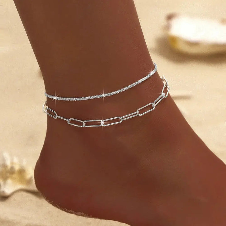Delicate women's double layer silver & gold ankle bracelet, a chic summer jewelry accessory.