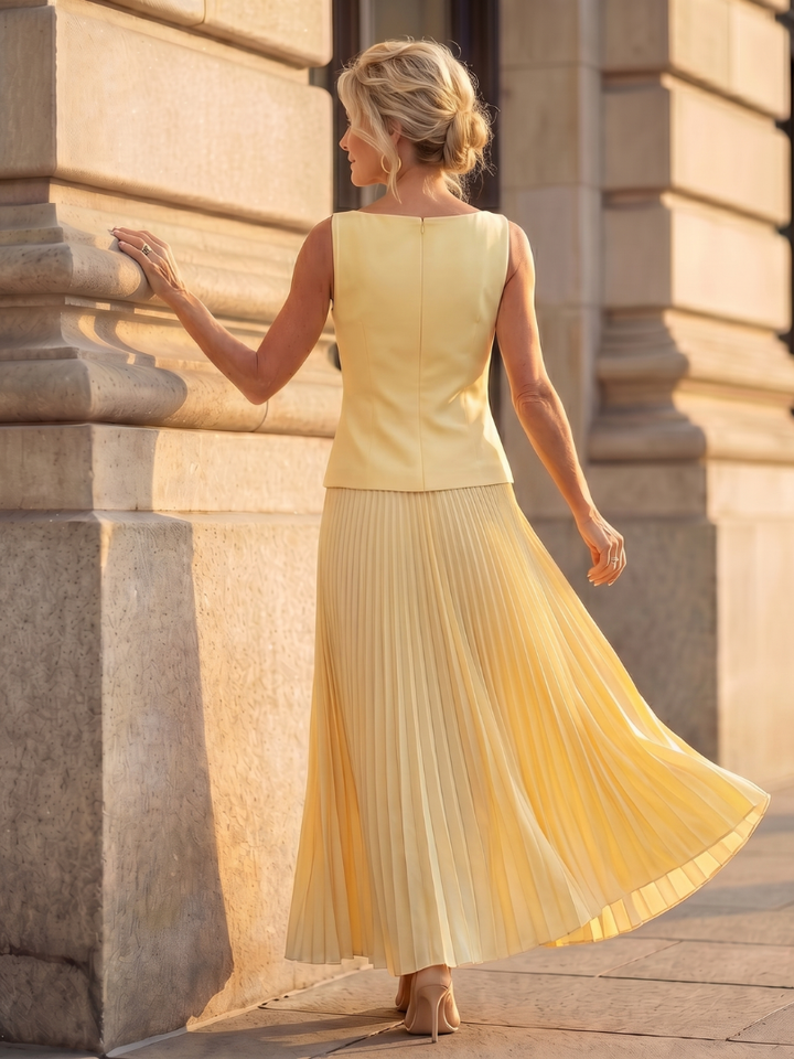Stylish women's two-piece with a sculpted bodice and graceful long pleated skirt, great for party wear.