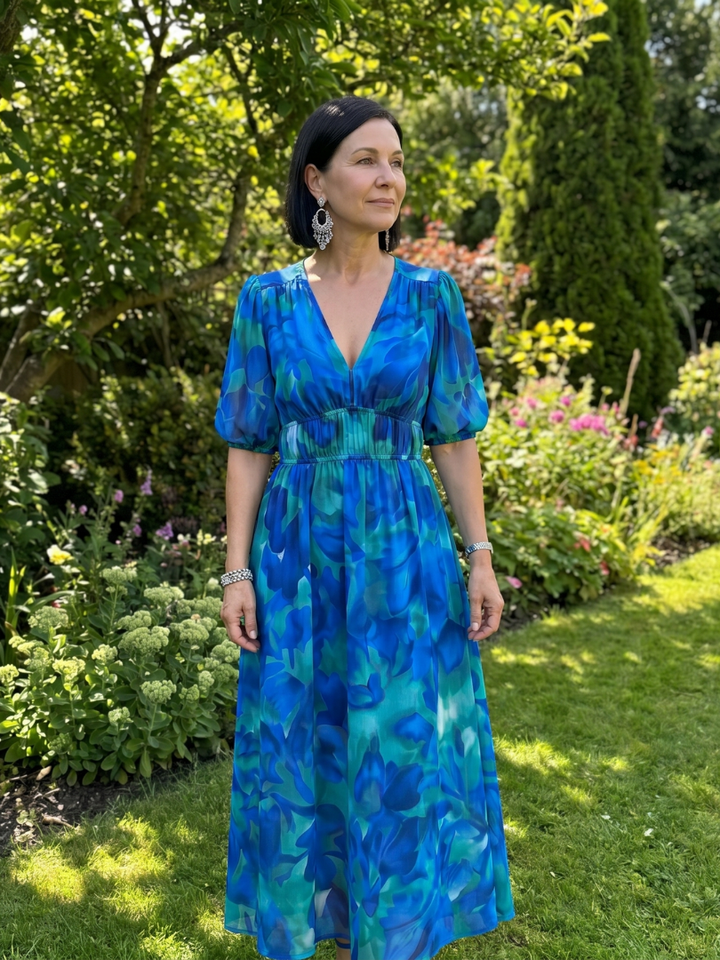 Vibrant abstract print women's midi dress with elegant puff sleeves and a comfortable V-neck, great spring fashion.