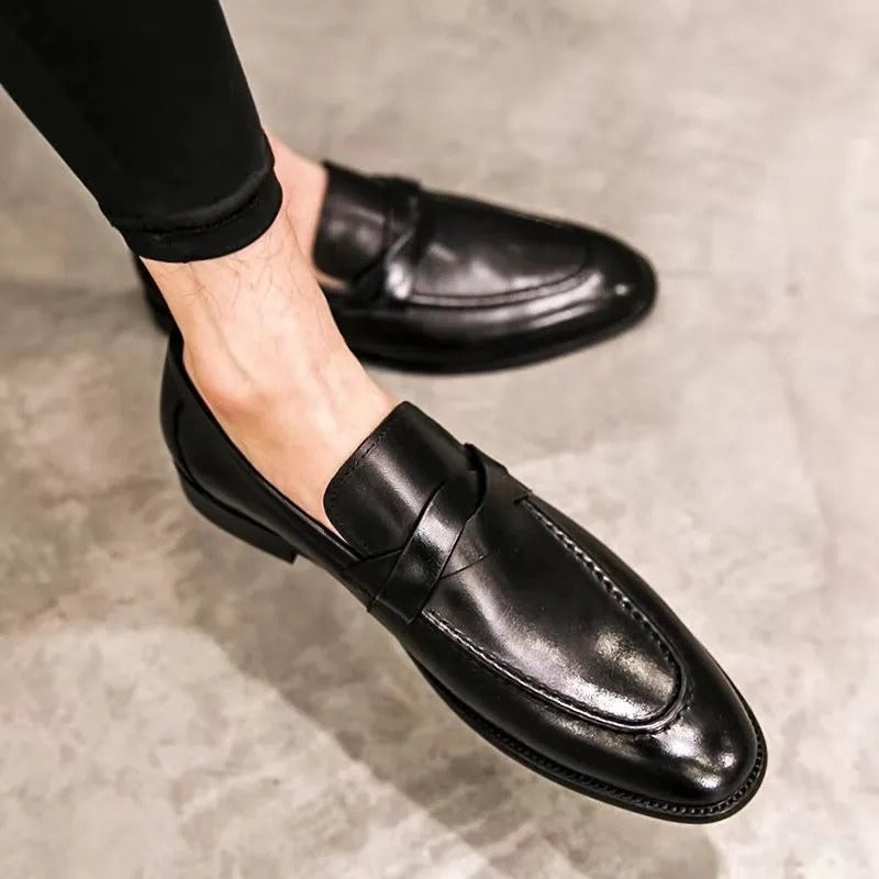 Man wearing polished black leather slip-on penny loafers, showcasing classic style & comfort for work or events.