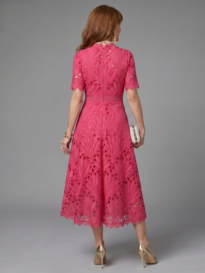 Full shot of a women's elegant pink eyelet lace midi dress, showcasing its flattering silhouette & short sleeves.