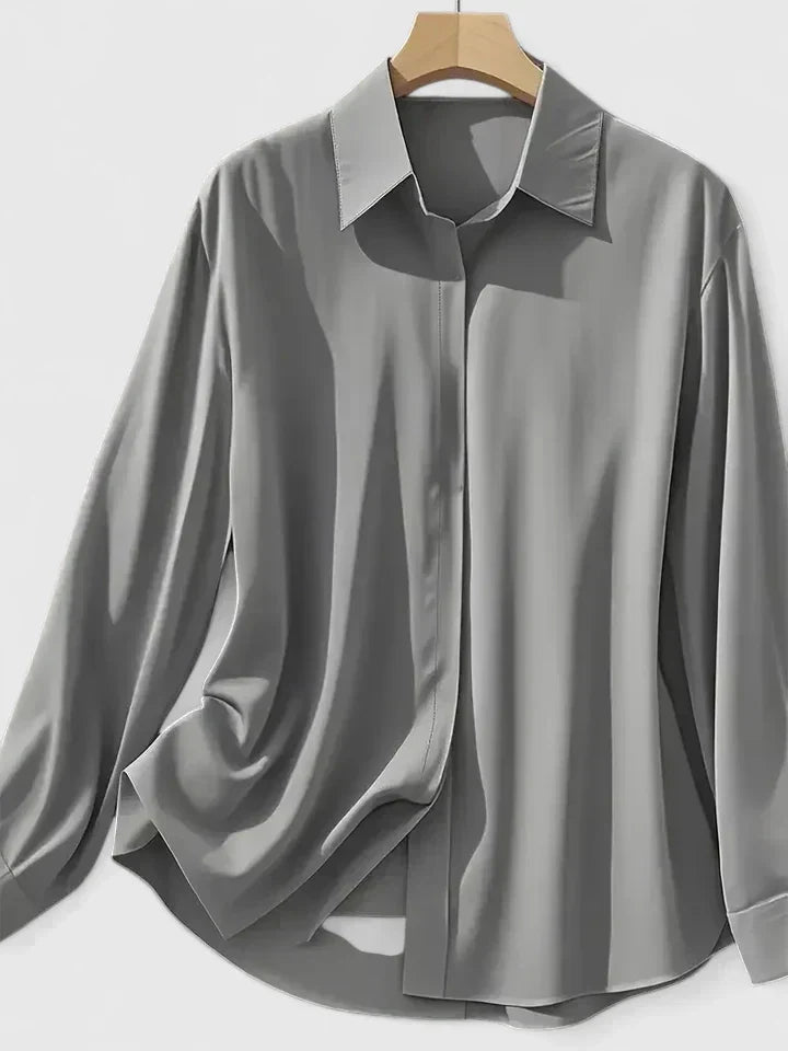Versatile women's button-down shirt, long sleeve & curved hem, ideal for office wear or casual elegance.