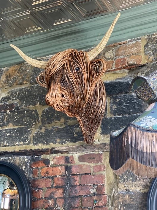Unique handwoven rattan Toro sculpture, rustic natural texture for boho wall decor.