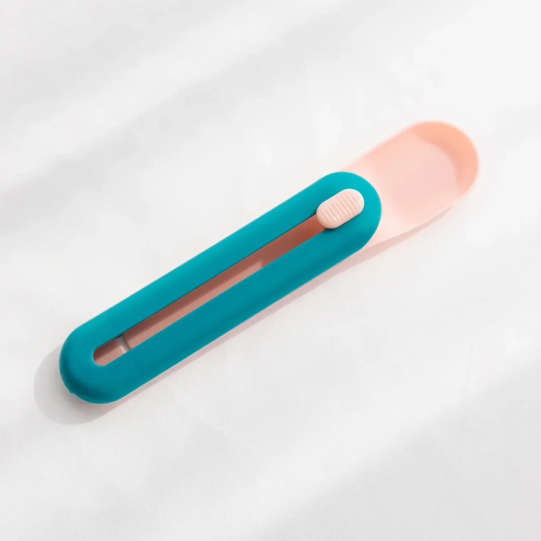 White pet food dispenser spoon with slider, perfect for feeding wet food to cats or small dogs.