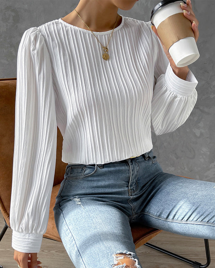 Classic white women's long sleeve shirt with a round neck, embodying timeless style & comfort.