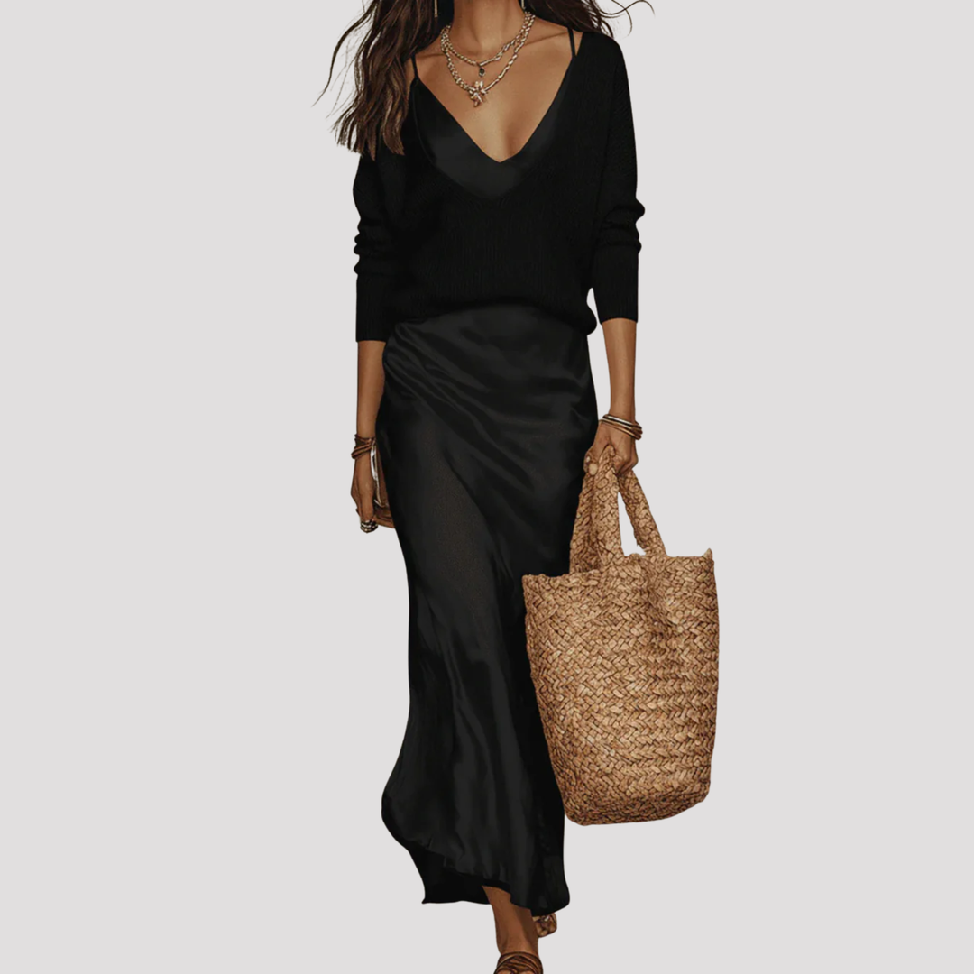 Woman wearing a stylish layered maxi dress. Elegant V-neck, long sleeves. Flowing silhouette for versatile wear.