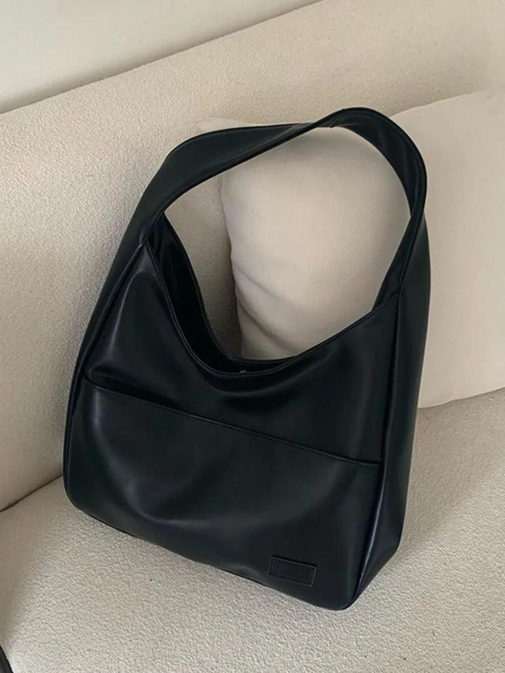 Woman wearing a chic vegan leather everyday shoulder bag. Stylish accessory for work, school, or casual outfits.