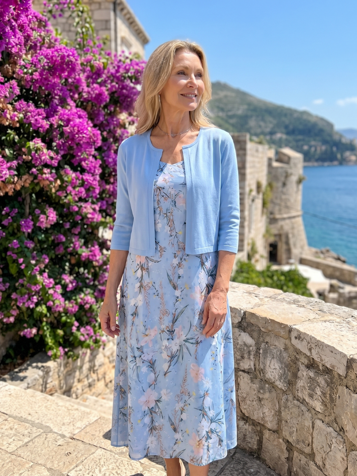 Sleeveless floral midi dress for women, styled with a matching cropped jacket. Versatile spring/summer outfit.