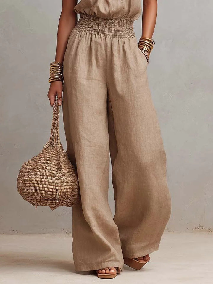 Elegant women's halter neck jumpsuit, wide-leg design & smocked waist for comfort and style.