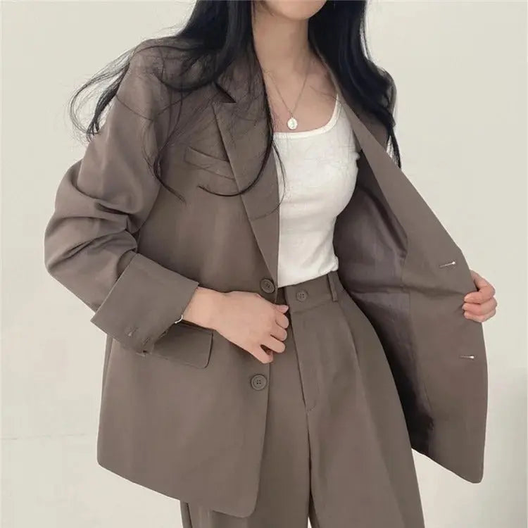 Front view of women's tailored outfit, a sleek blazer and elegant trouser set.