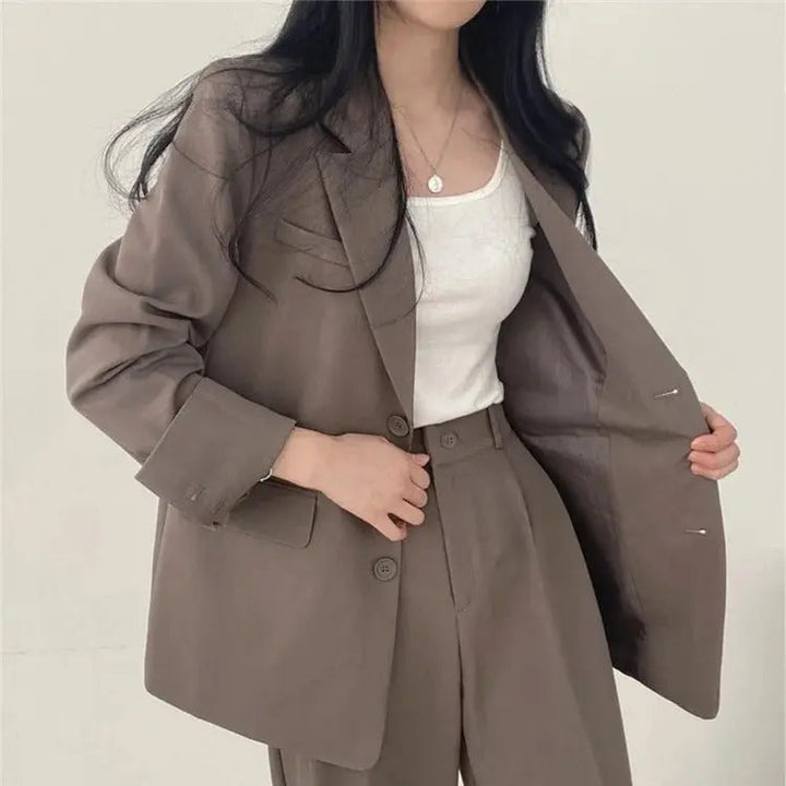 Front view of women's tailored outfit, a sleek blazer and elegant trouser set.