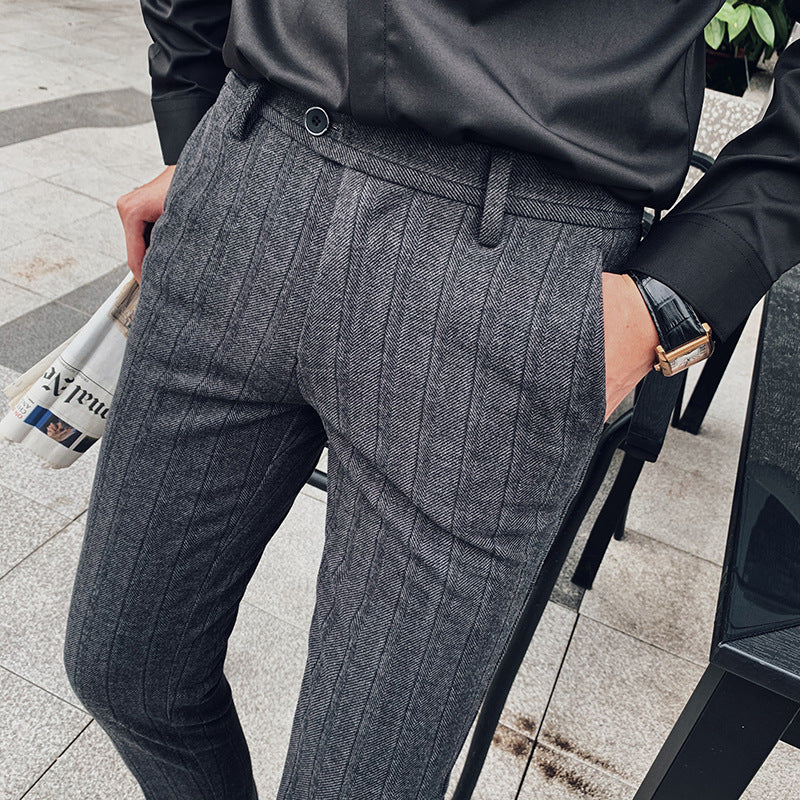 Close-up of elegant men's herringbone dress pants, showcasing the unique textured fabric and slim fit.