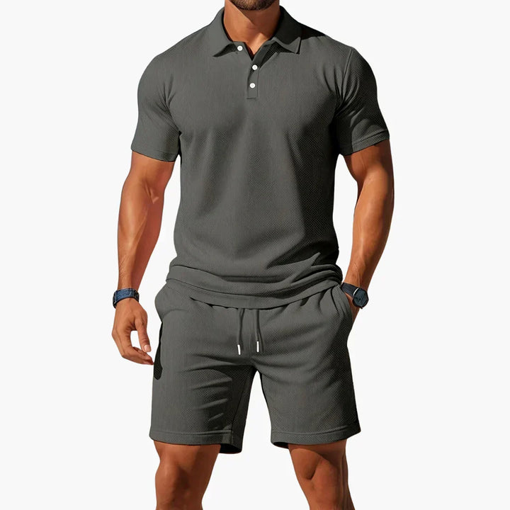 Man modeling a two-piece men's summer set: a premium polo shirt and coordinating shorts.