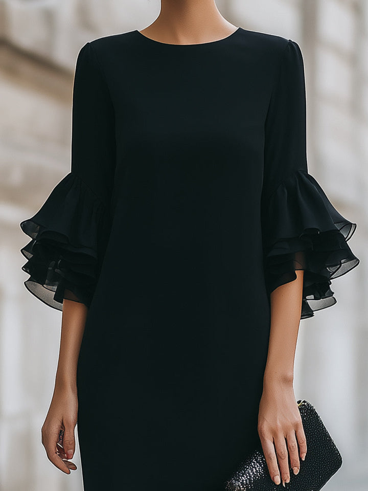 Front view of a women's elegant black midi funeral dress with delicate ruffled sheer sleeves and a modest, formal knee-length skirt.