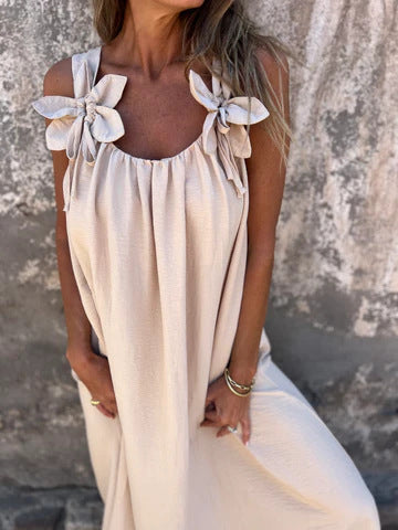 Full-length view of a women's elegant flowing U-neck maxi dress with charming bow straps & feminine design.