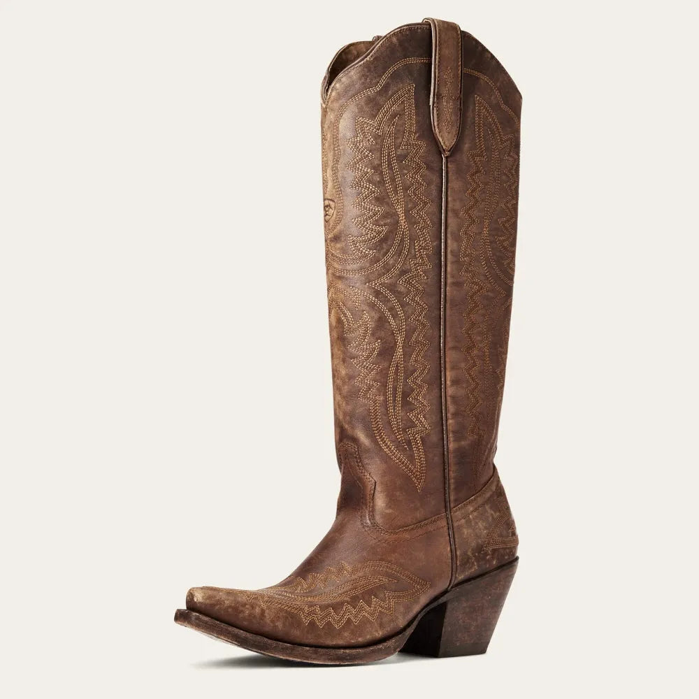Women's patterned tall boots in motion, showing off the pointed toe, zip, & elegant silhouette.