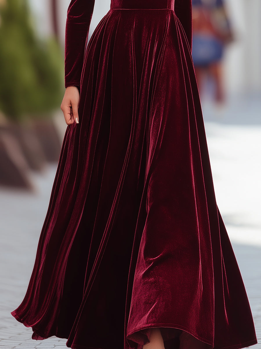 Modest dark green long sleeve pleated dress, featuring a high waist and mock neck, suitable for elegant events.