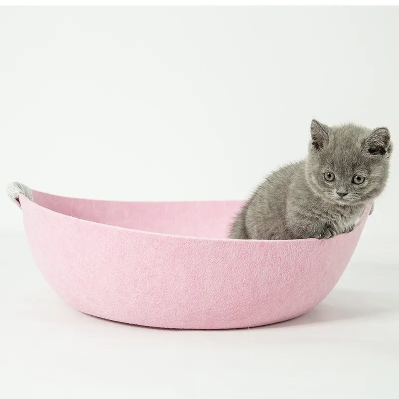 Portable felt pet bed, a soft basket with integrated handles, perfect for a cat's cozy nap.