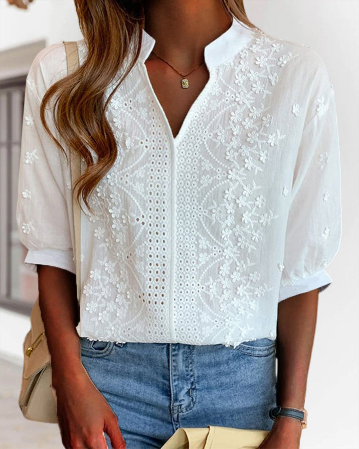 Woman wearing a flattering white puff sleeve V-neck blouse, showcasing its elegant summer style.