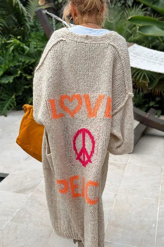 Colorful women's oversized cardigan with a distinctive 'Love & Peace' design, embodying trendy hippie chic style.