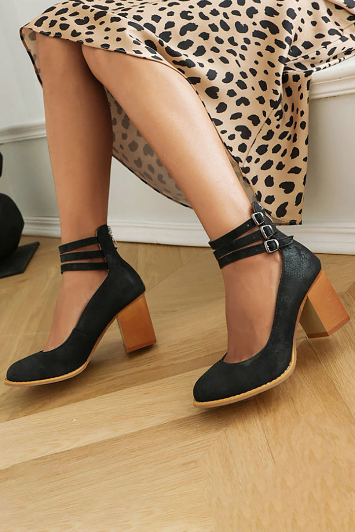 Close-up of the elegant ankle strap and stable block heel on women's fashion footwear.