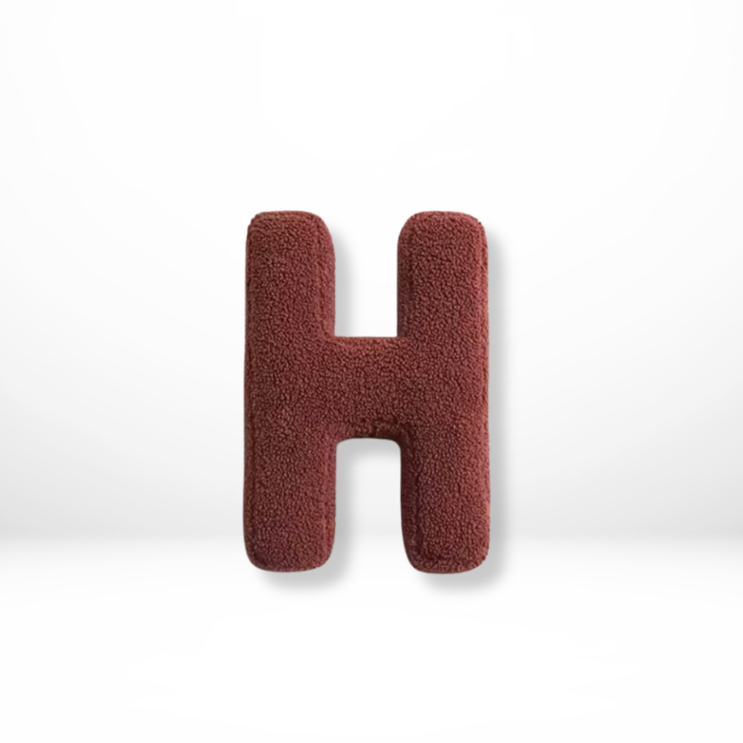 Elegant velvet 'L' letter cushion, ideal for initial decor, adding luxury to stylish home accents.