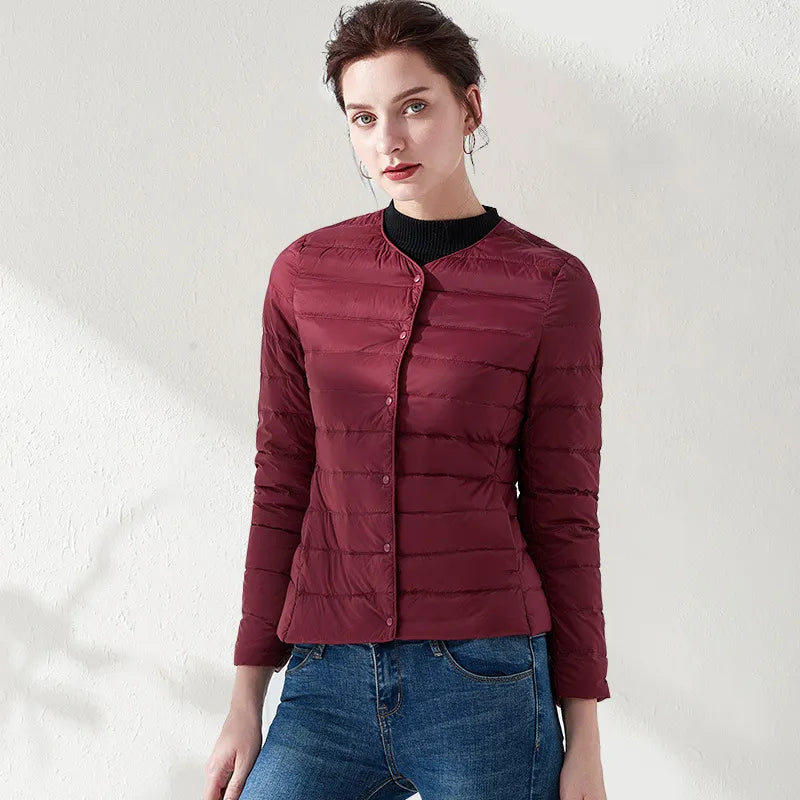 Practical women's collarless puffer jacket. Lightweight design provides a slimming fit for daily outerwear.