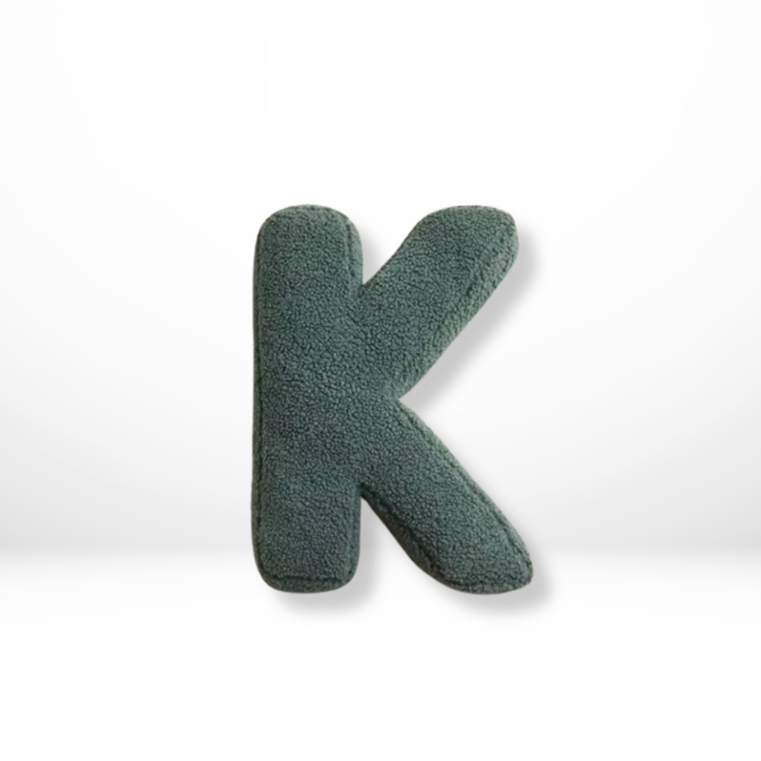 Luxurious velvet 'O' alphabet pillow, a soft decorative furnishing for elegant home interior design.